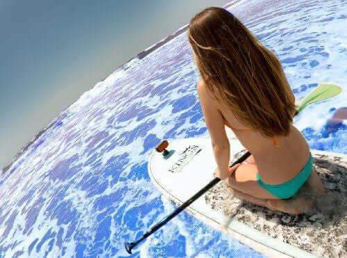 Woman on paddle board with ECOXGEAR suction cup mount on ocean, promoting Cabin Depot accessories for adventure.