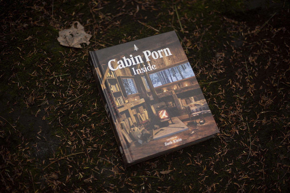 Cabin Porn Inside Book on forest floor - Explore tranquil cabins and homebuilding inspirations. Available at Cabin Depot.