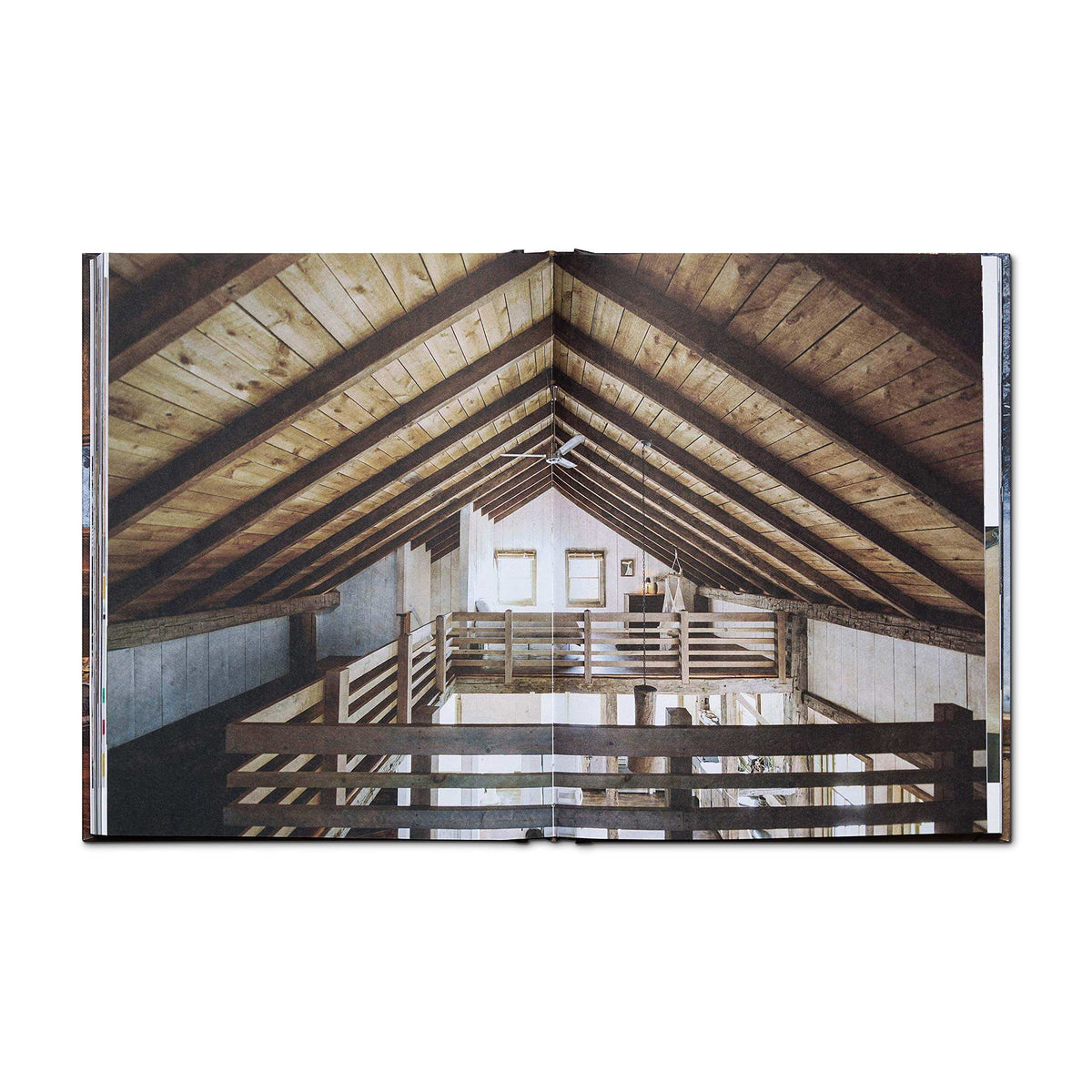 Open book displaying a rustic cabin interior with wooden beams, inspired by the Cabin Porn movement. Available at Cabin Depot.