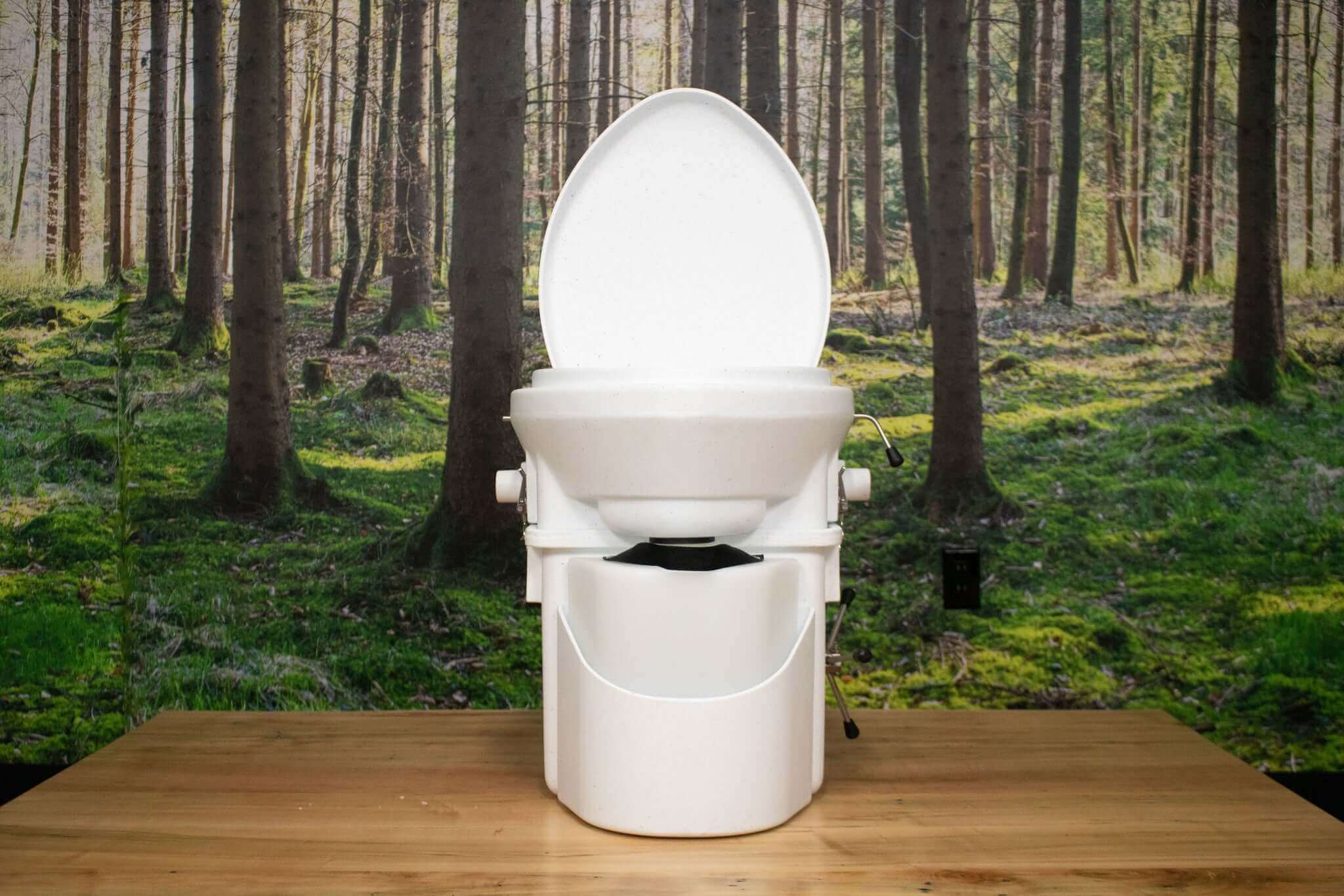 Nature's Head Composting Toilet with Spider Handle from Cabin Depot in a forest setting.