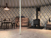Cozy cabin interior featuring Drolet Fox Wood Stove by Cabin Depot, ideal for heating up to 1,200 ft² with 45,000 BTU/h efficiency.
