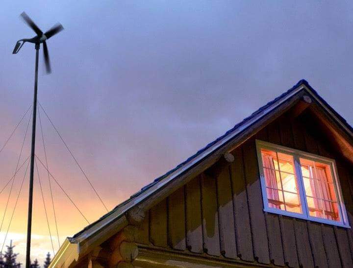 Primus AIR 40 wind turbine next to a cabin at sunset, ideal for remote off-grid energy solutions by Cabin Depot.