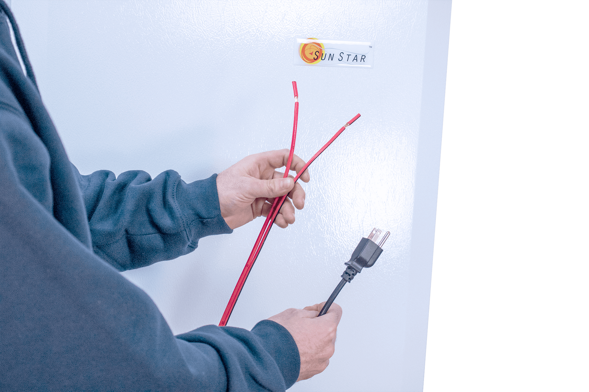 Person connecting cables to SunStar solar refrigerator, highlighting Cabin Depot's solar-powered appliance setup.