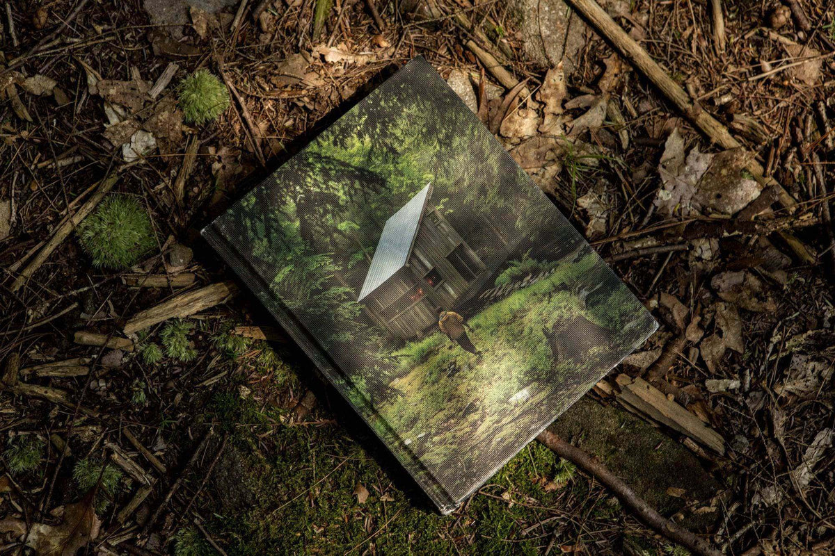 Alt Tag: Cabin Porn Book on forest floor - explore rural escapes with Cabin Depot's inspirational collection.