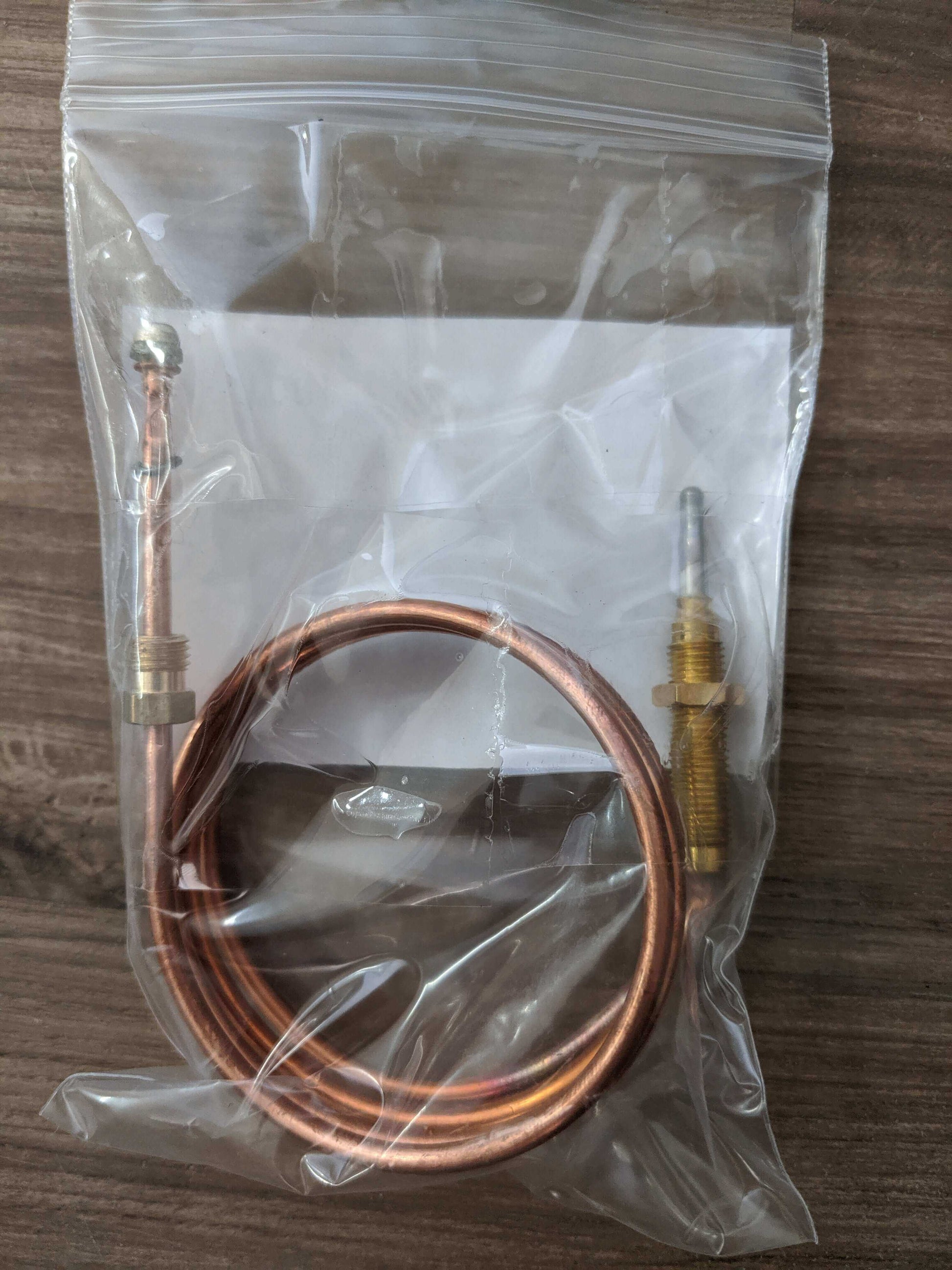 Unique Thermocouple for older Consul fridges and Zero GEV70 from Cabin Depot, shown coiled inside a clear bag on a wooden surface.