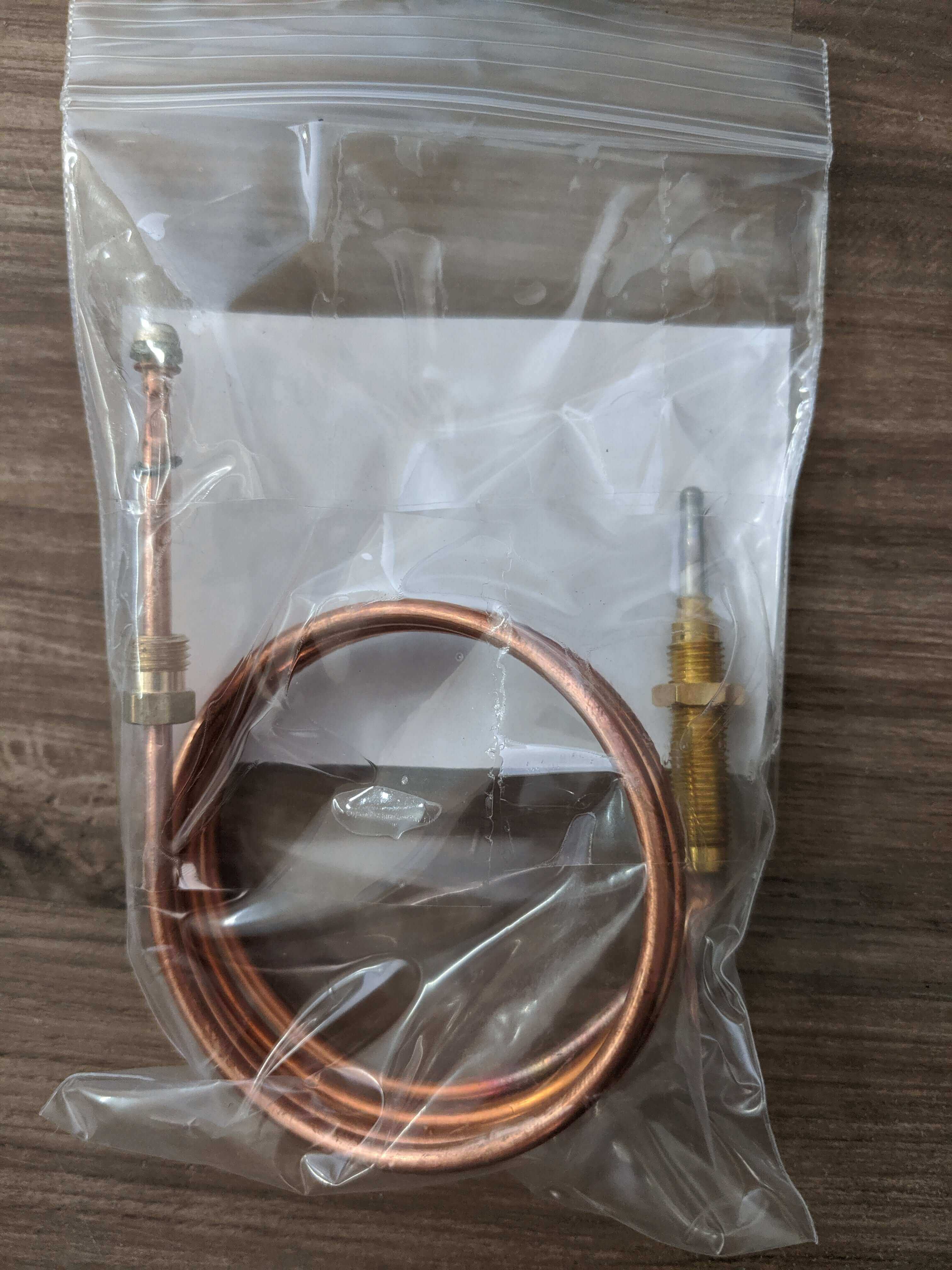 Unique Thermocouple for older Consul fridges and Zero GEV70 from Cabin Depot, shown coiled inside a clear bag on a wooden surface.